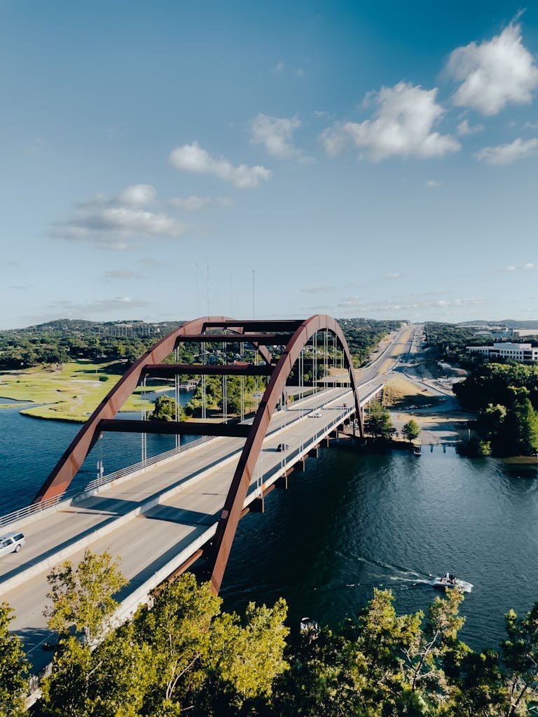 A stunning aerial shot of Pennybacker Bridge over Lake Austin on a clear summer day.